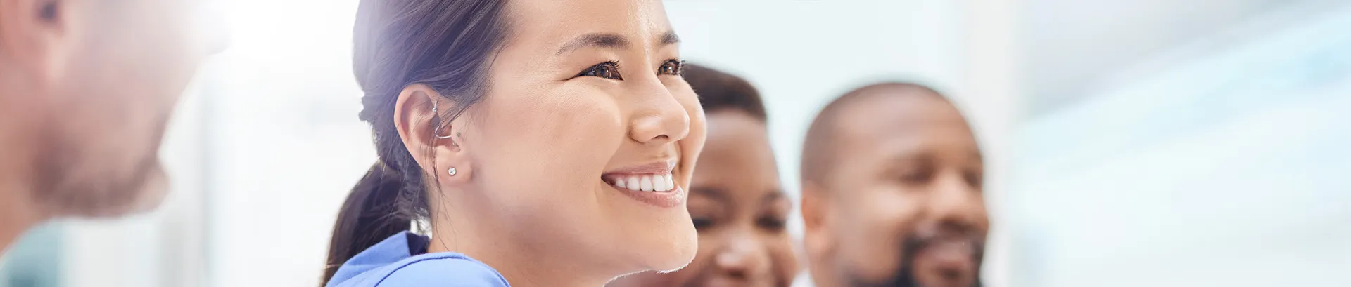 A group of women and men doctors are siting in a row and smiling