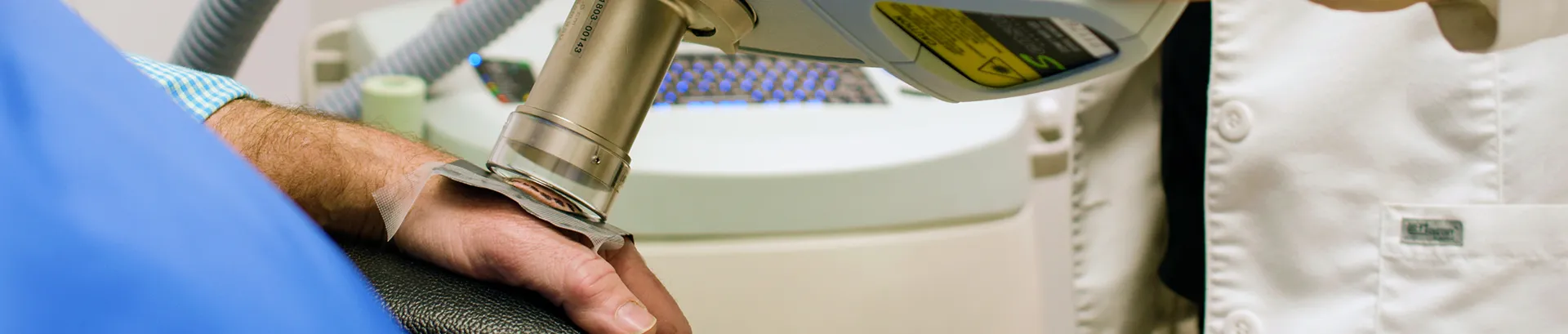 A doctor performing radiotherapy on a patient's hand